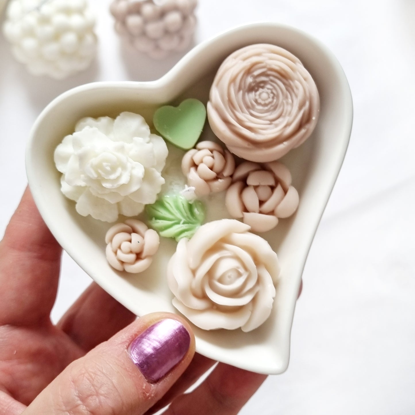 vegane Sojakerze mit Blüten in dekorativer Herzschale