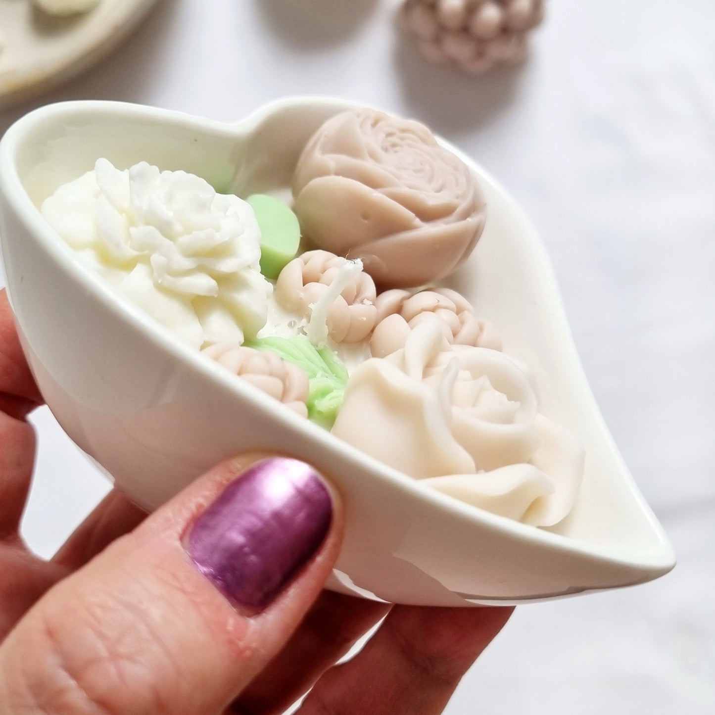 vegane Sojakerze mit Blüten in dekorativer Herzschale