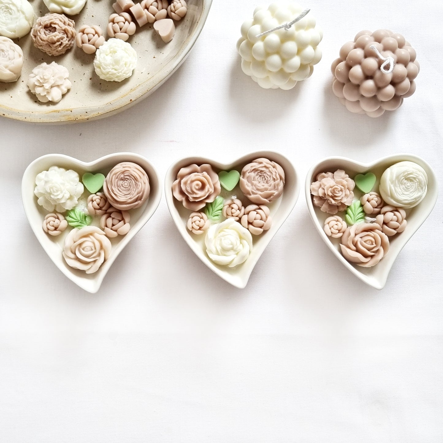 vegane Sojakerze mit Blüten in dekorativer Herzschale