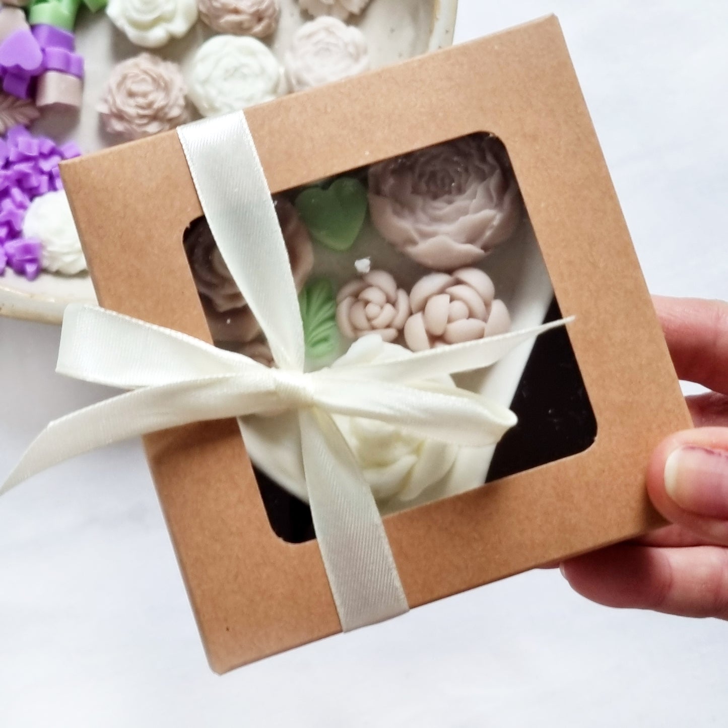vegane Sojakerze mit Blüten in dekorativer Herzschale