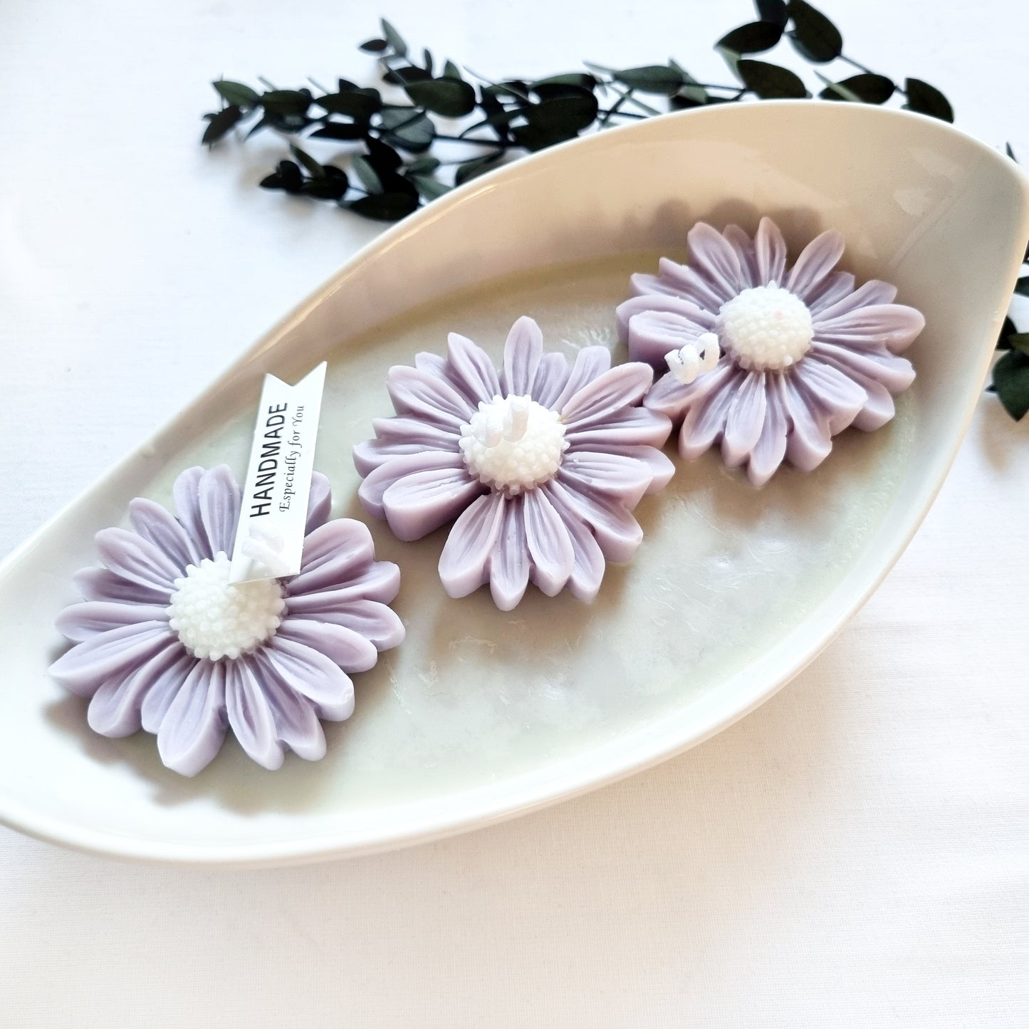 vegane Sojakerze mit Blüten in dekorativer Schiffschale